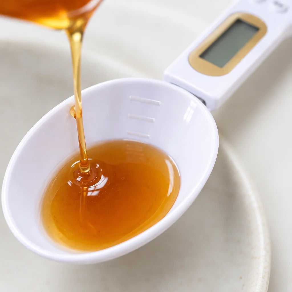 A tight macro photograph looking into the oval bowl of the exact white digital measuring spoon, with